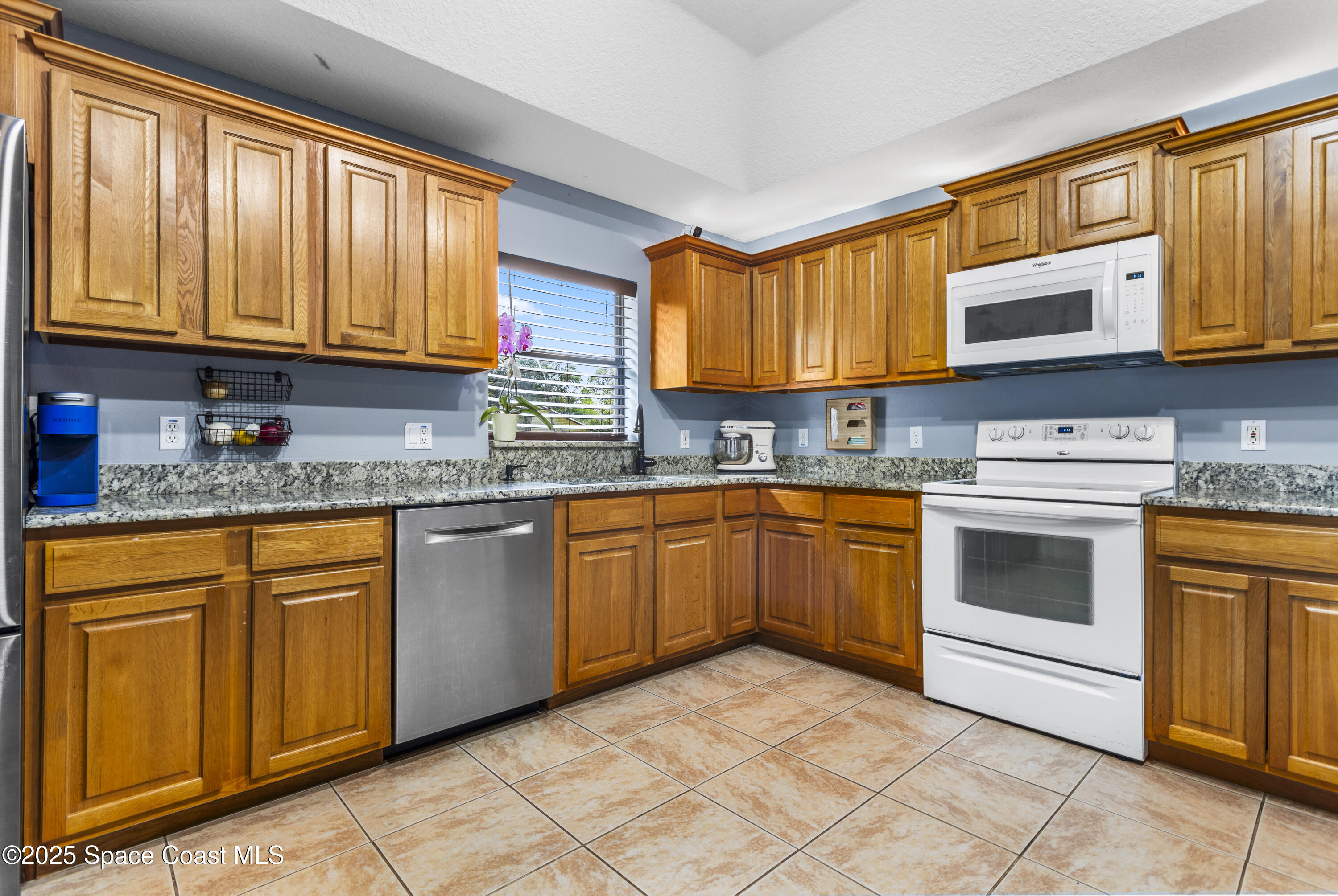 5964 Travis Street Mims, FL 32754 - Photo 25 of 45 a kitchen with stainless steel appliances granite countertop a stove sink and cabinets