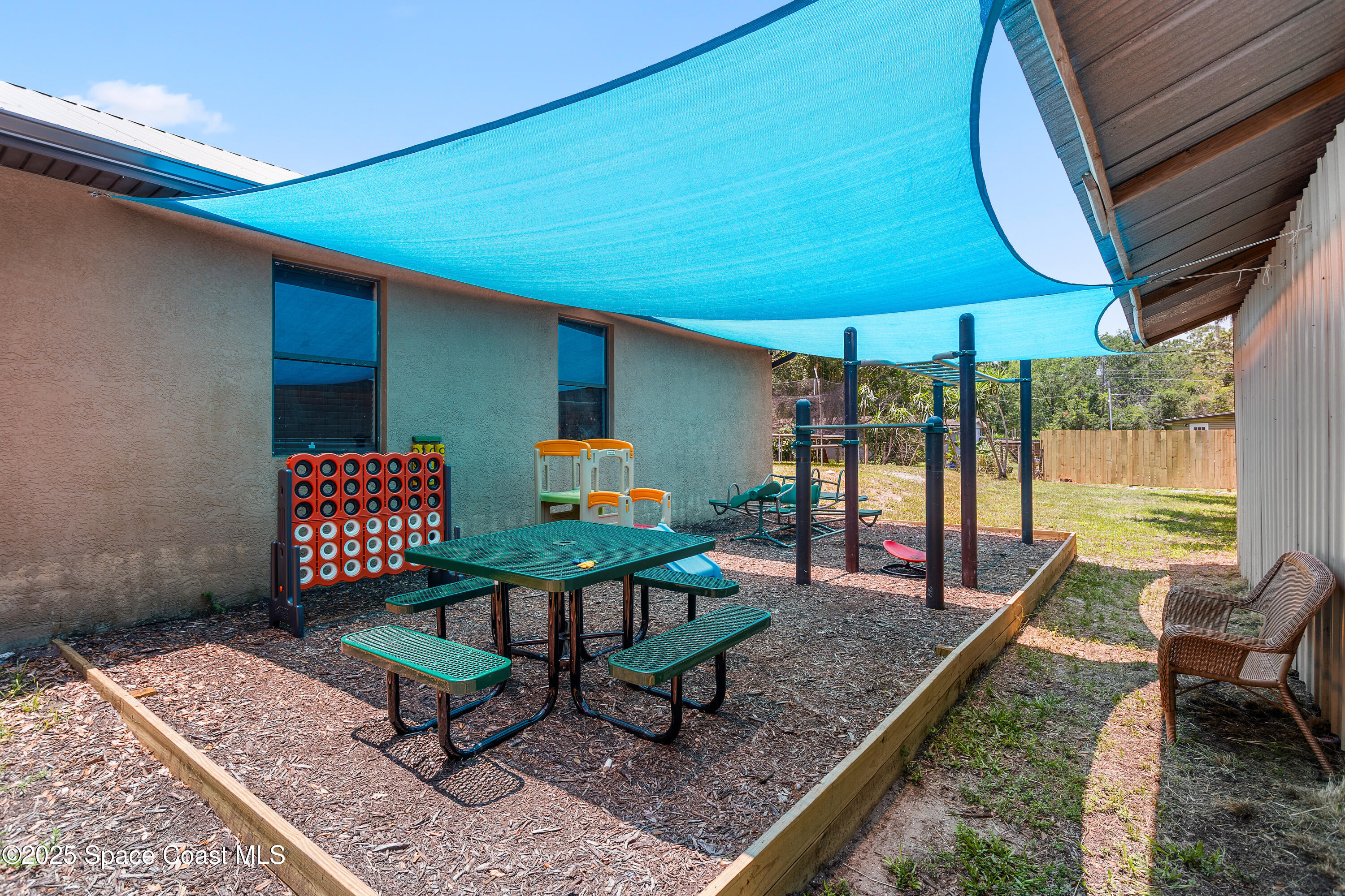 5964 Travis Street Mims, FL 32754 - Photo 29 of 45 a outdoor sitting area with furniture and umbrella