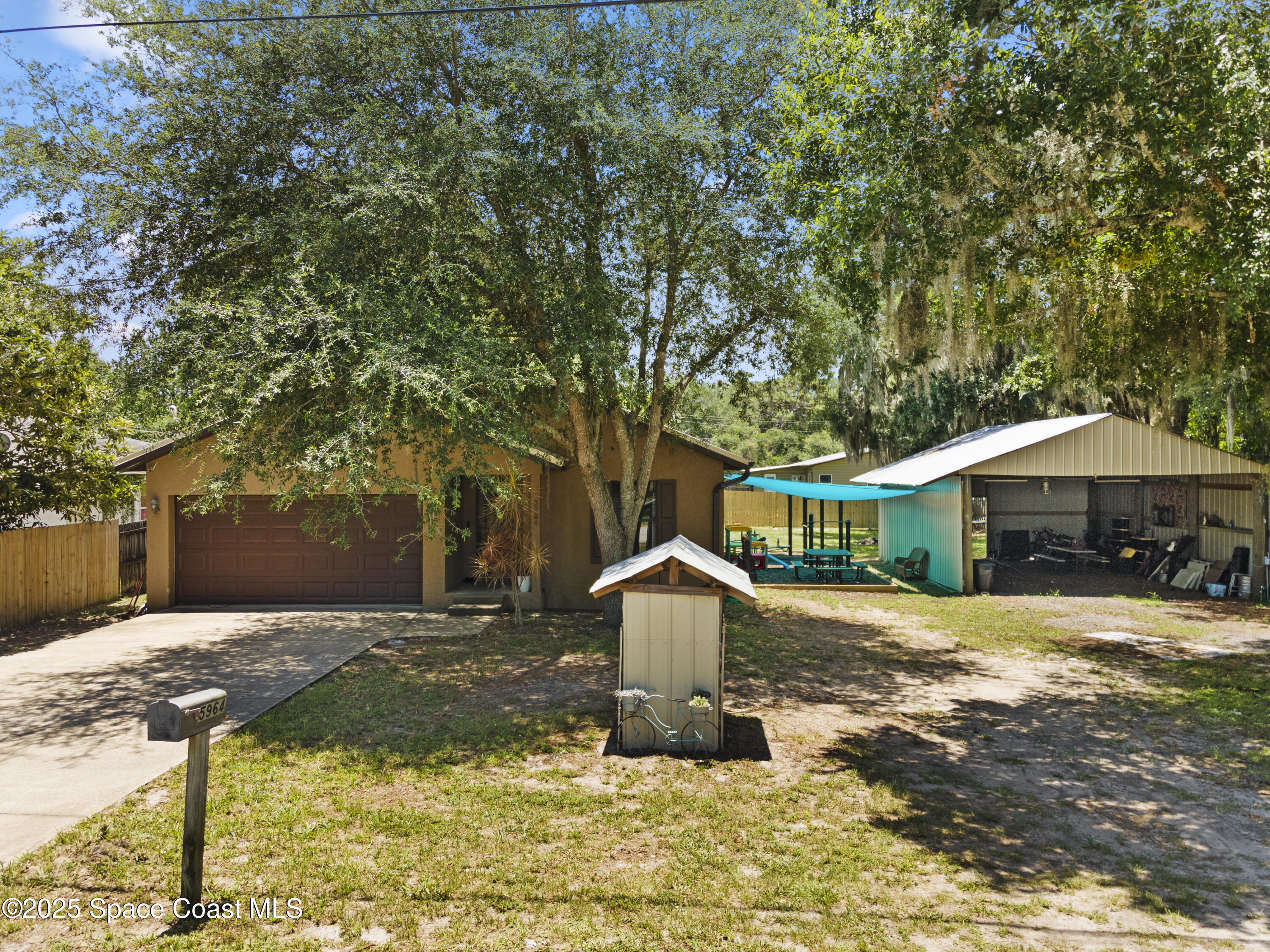 5964 Travis Street Mims, FL 32754 - Photo 3 of 45 a front view of a house with yard tree and green space