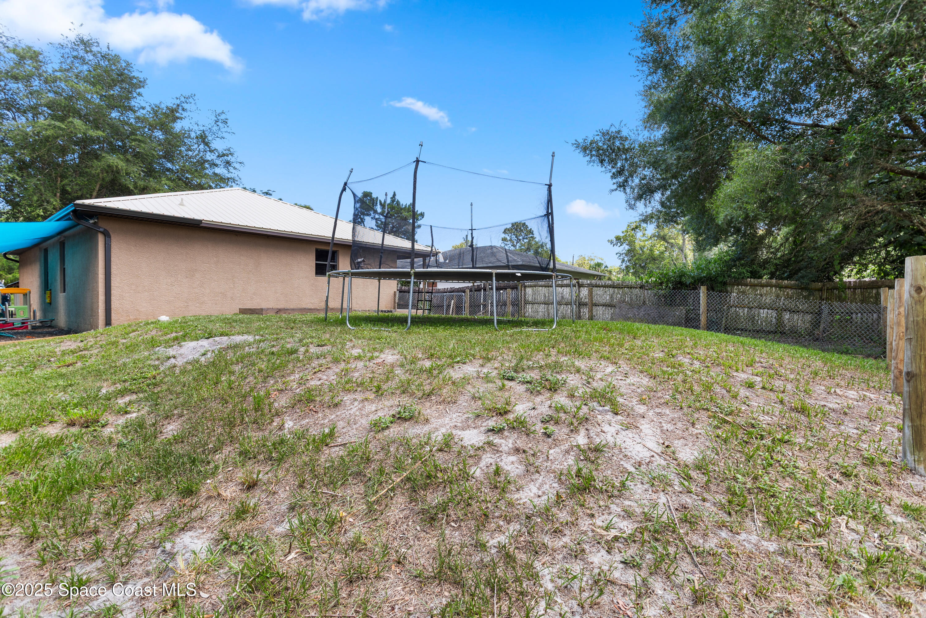 5964 Travis Street Mims, FL 32754 - Photo 31 of 45 a view of a swimming pool with a patio and a yard
