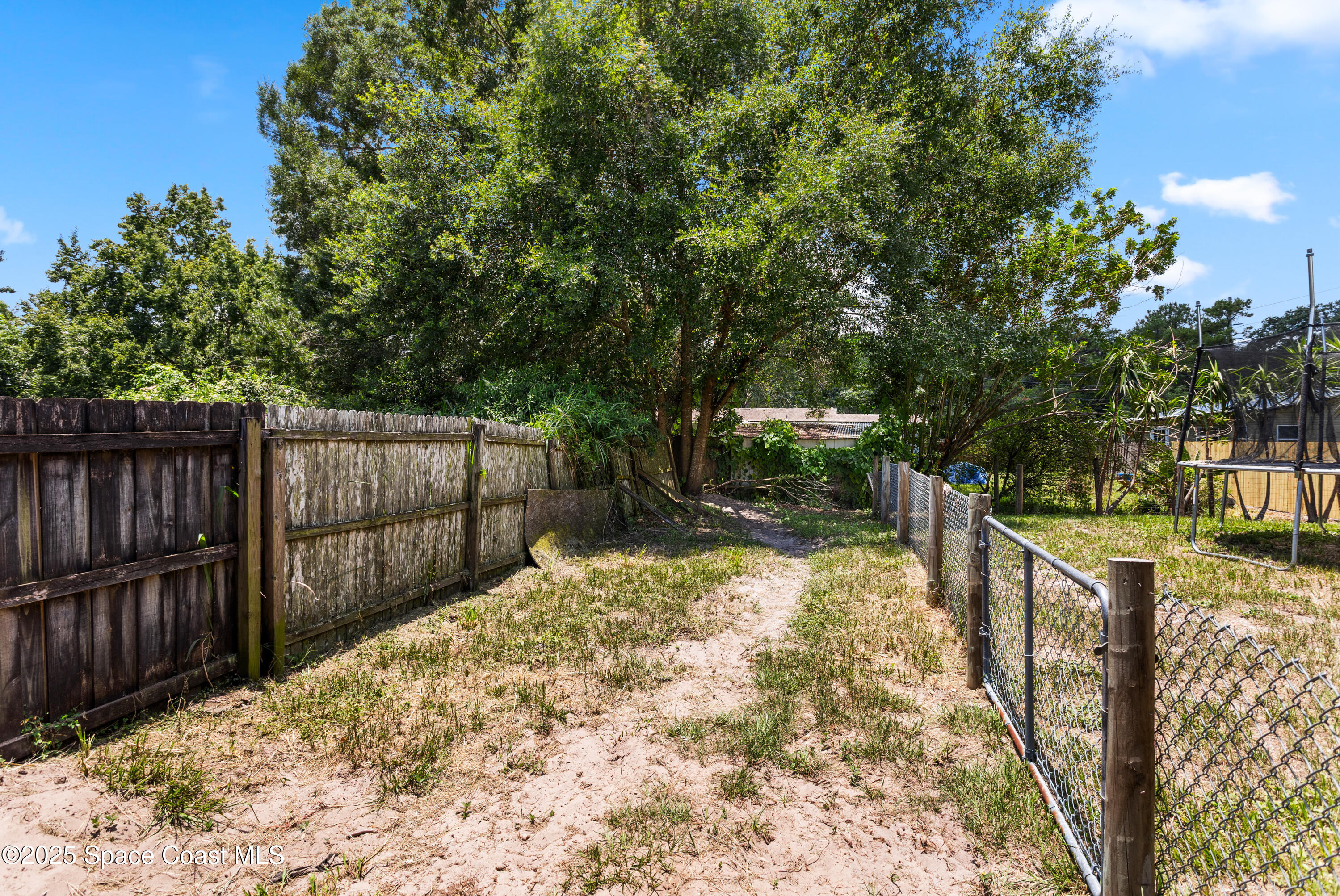 5964 Travis Street Mims, FL 32754 - Photo 36 of 45 a view of a backyard with wooden fence and large trees
