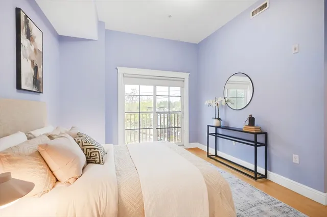 a bedroom with a bed a mirror and a window