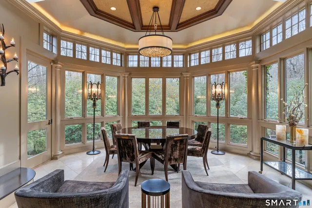 a dining room with furniture a large window and a chandelier