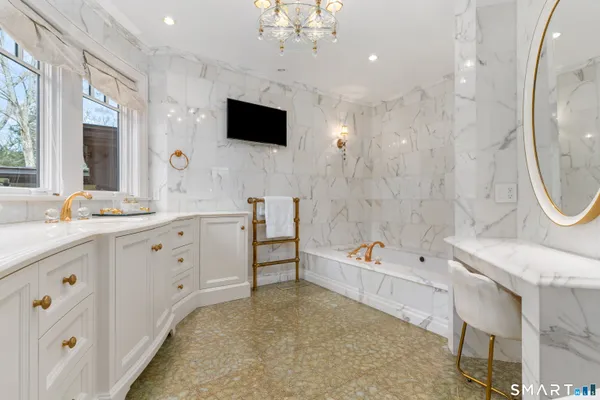 a spacious bathroom with a double vanity sink a mirror a bathtub and a shower