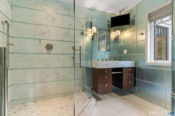 a bathroom with a sink mirror and shower