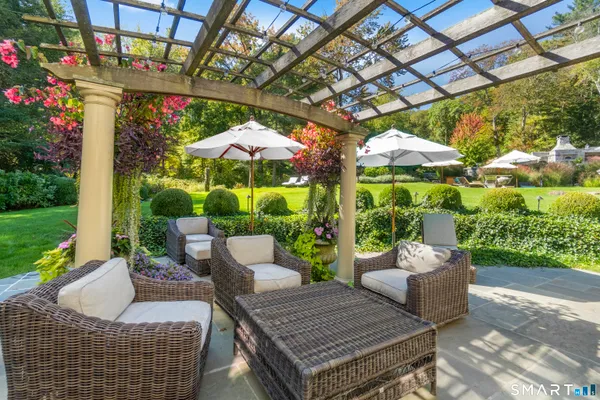 a view of a patio with couches and table and chairs under an umbrella