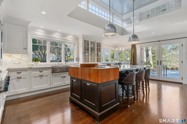 a living room with kitchen island granite countertop furniture a large window and stainless steel appliances