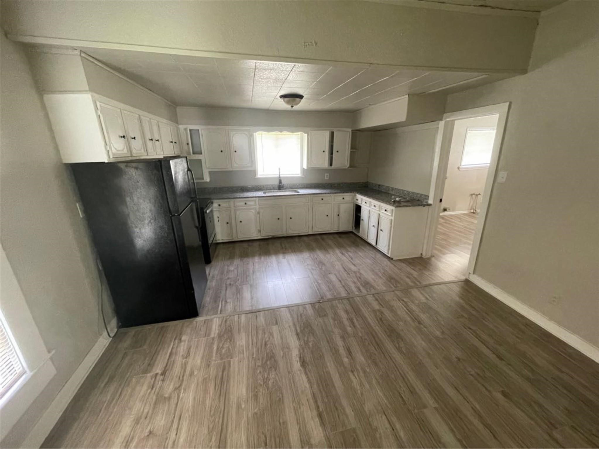 2010 13th Street Port Arthur, TX 77640 - Photo 12 of 22 a view of a refrigerator in kitchen and wooden floor