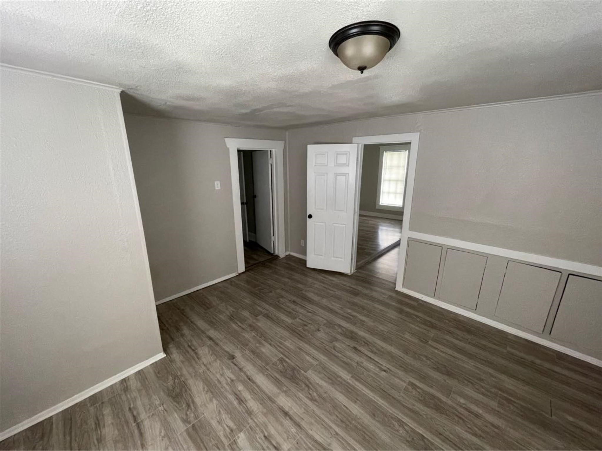 2010 13th Street Port Arthur, TX 77640 - Photo 19 of 22 an empty room with wooden floor and windows