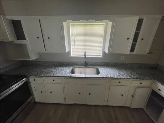 a view of a sink a mirror and cabinets