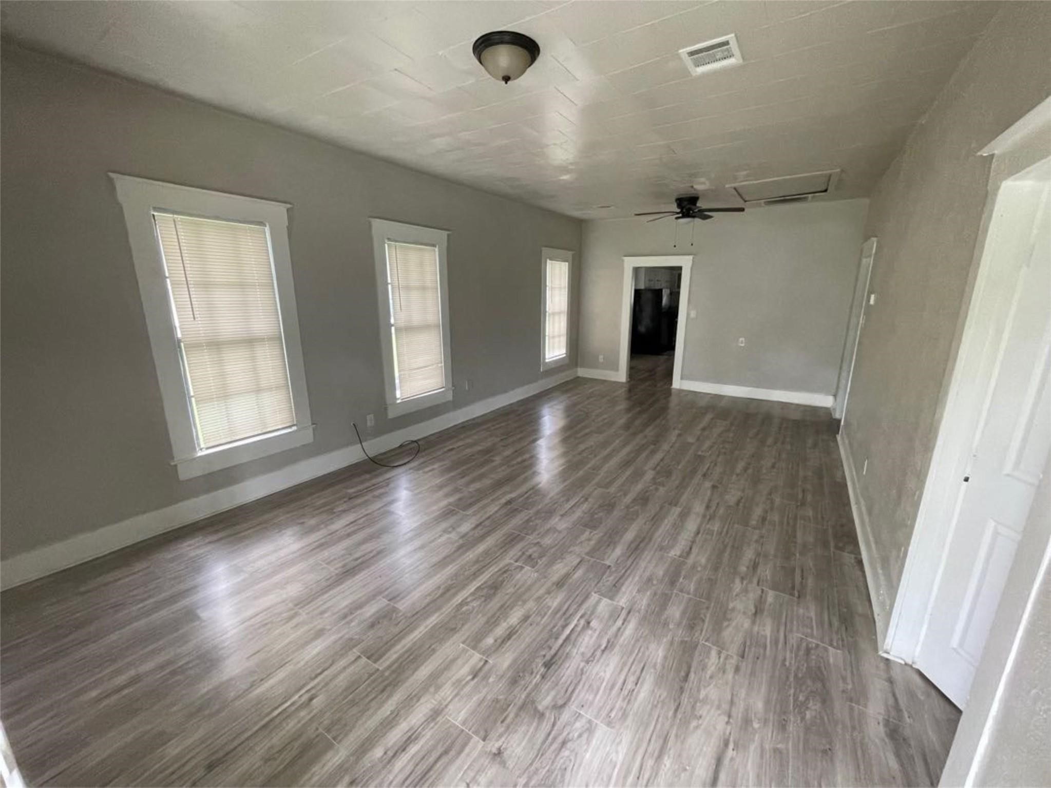 2010 13th Street Port Arthur, TX 77640 - Photo 7 of 22 wooden floor in an empty room with a window