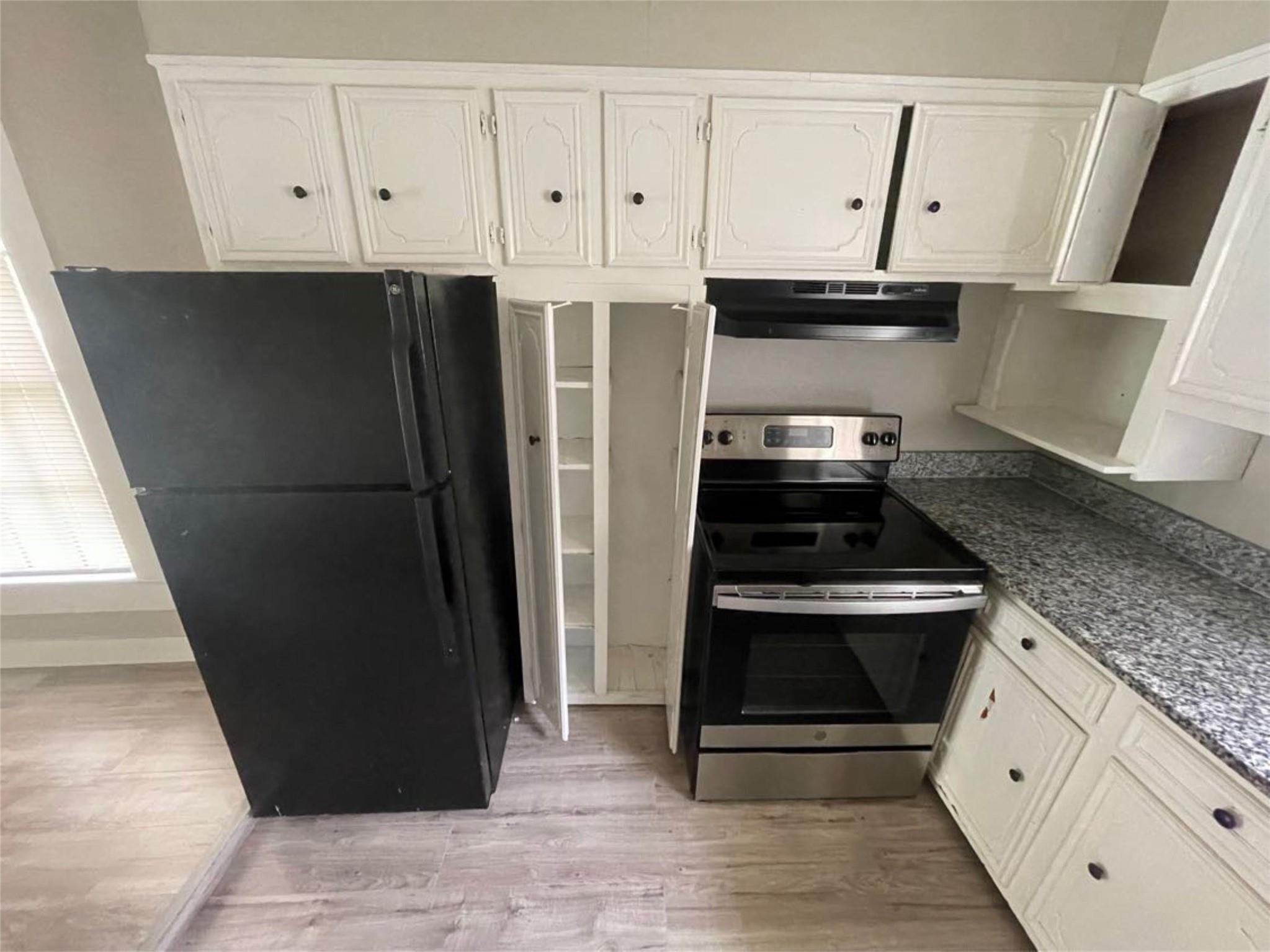 2010 13th Street Port Arthur, TX 77640 - Photo 9 of 22 a kitchen with granite countertop white cabinets and stainless steel appliances
