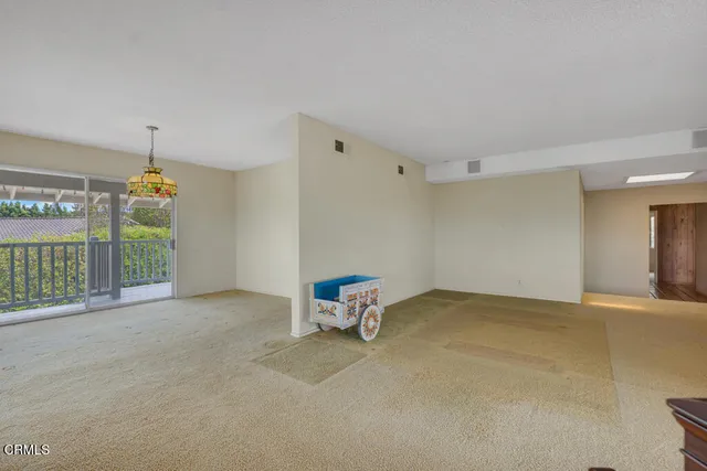 a view of empty room with floor to ceiling window and ceiling fan