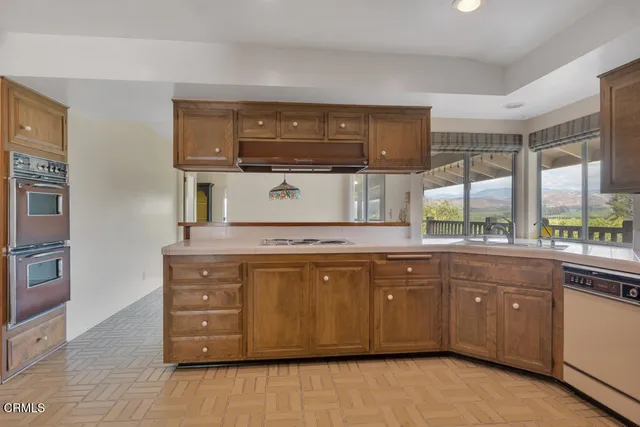 a kitchen with stainless steel appliances granite countertop a refrigerator a oven and a wooden floors