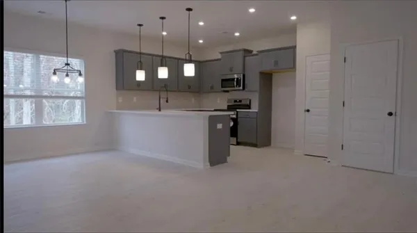 a kitchen with kitchen island white cabinets and refrigerator