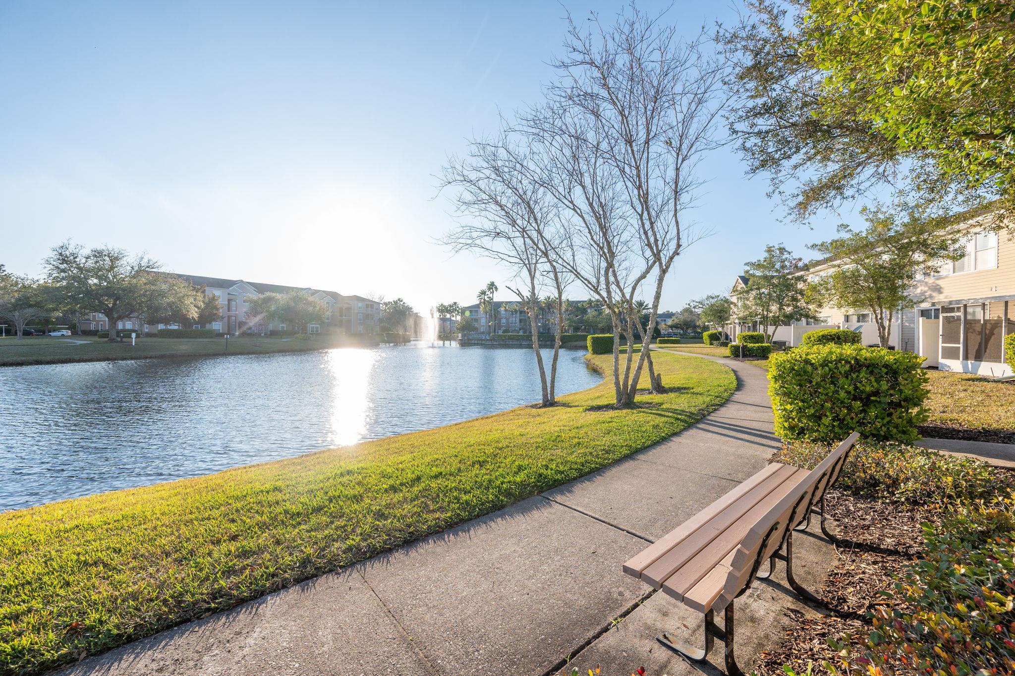 7990 Baymeadows Road East, Unit 1308 Jacksonville, FL 32256 - Photo 38 of 45 a view of a lake with a yard and a large tree