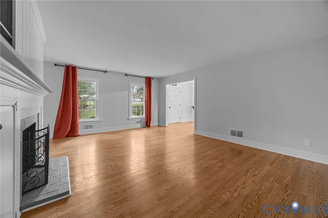 wooden floor in an empty room with a fireplace
