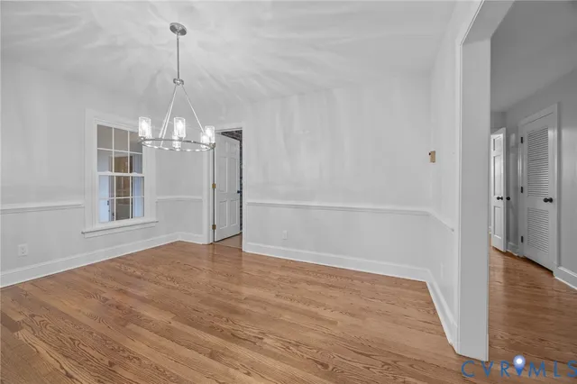 a view of empty room with wooden floor and window