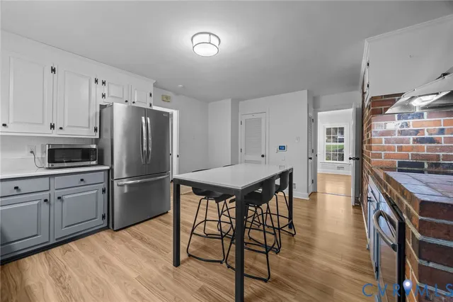 a kitchen with stainless steel appliances granite countertop a stove refrigerator and a view of living room