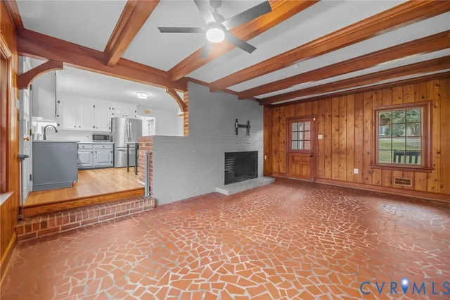 a view of an empty room with a fireplace and a window