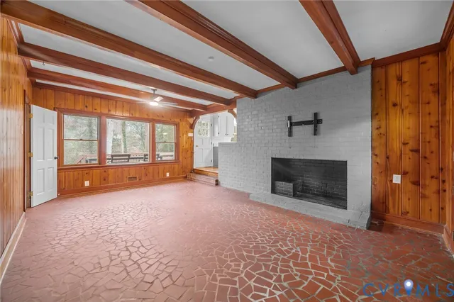 a view of an empty room with a fireplace and a window