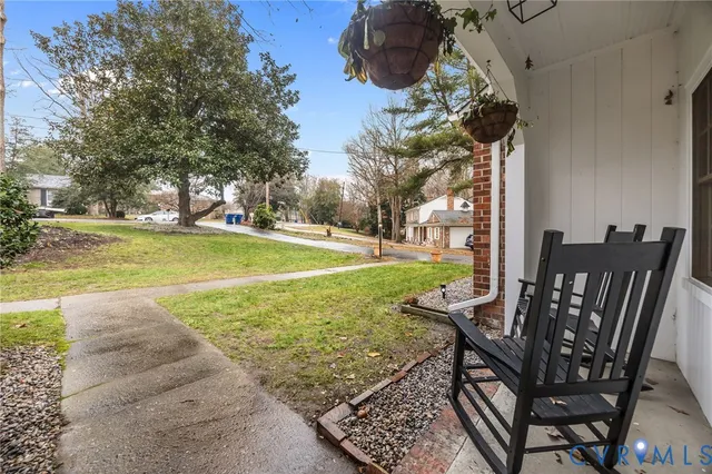 a view of a patio with table and chairs potted plants and large tree