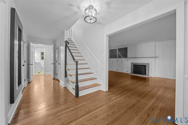 a view of a hallway with wooden floor and staircase