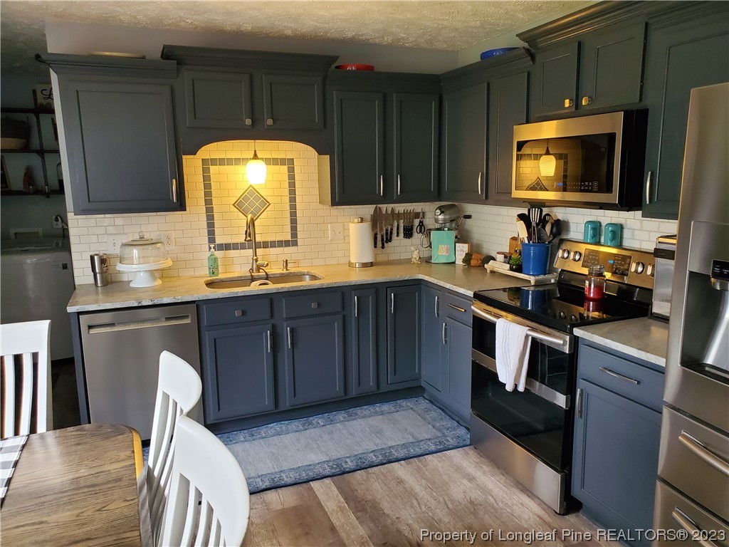 563 Sawyer Road Cameron, NC 28326 - Photo 23 of 43 a kitchen with a sink a stove and cabinets