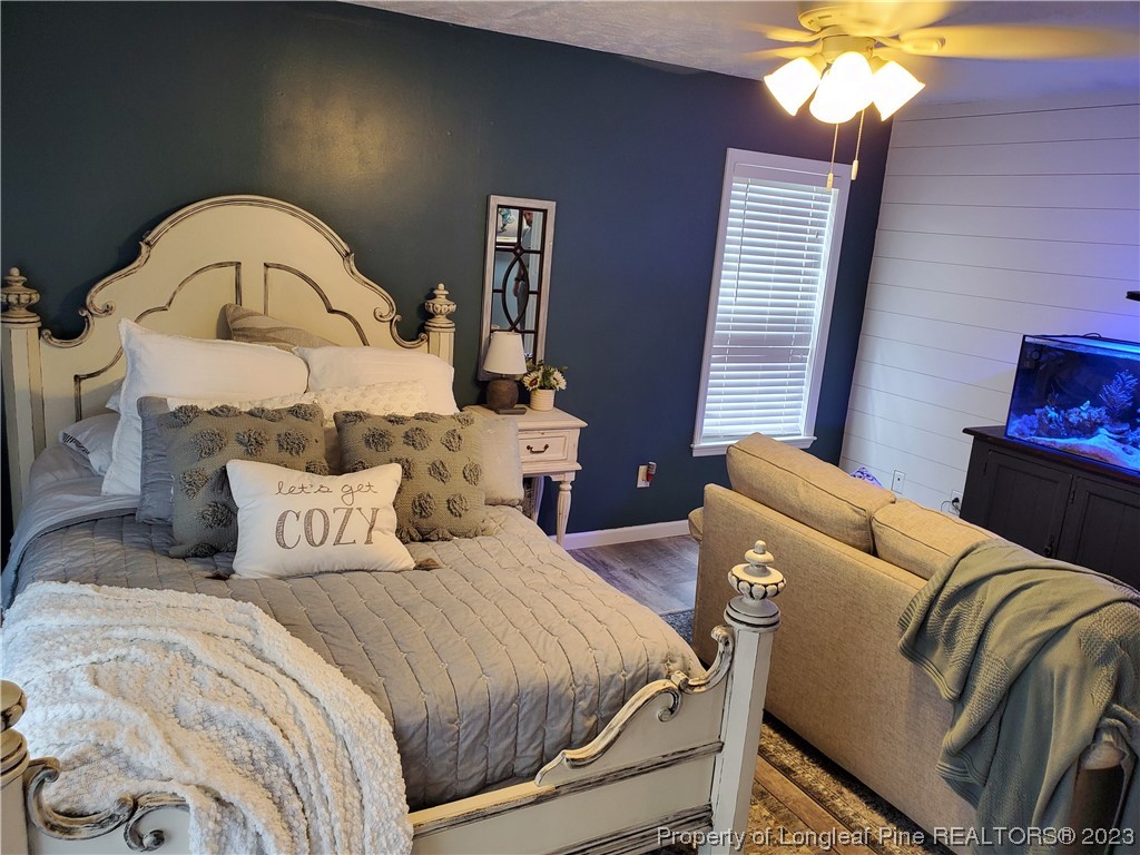 563 Sawyer Road Cameron, NC 28326 - Photo 29 of 43 a bedroom with a bed and a chandelier