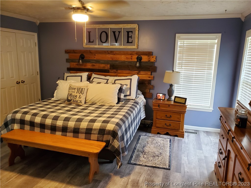 563 Sawyer Road Cameron, NC 28326 - Photo 34 of 43 a bedroom with a bed and wooden floor