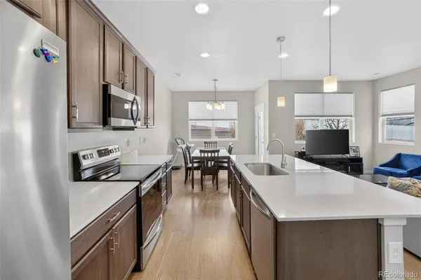 a kitchen with counter top space a sink appliances and cabinets