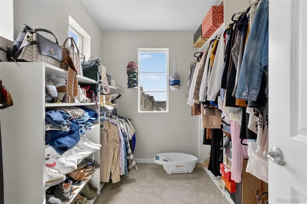 a view of walk in closet with clothes and shoes