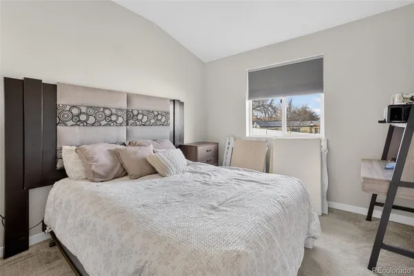 a large bed sitting in a bedroom next to a window