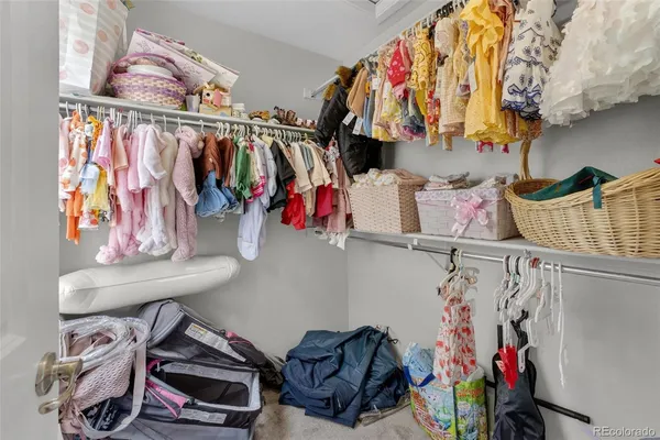 a view of walk in closet with clothes