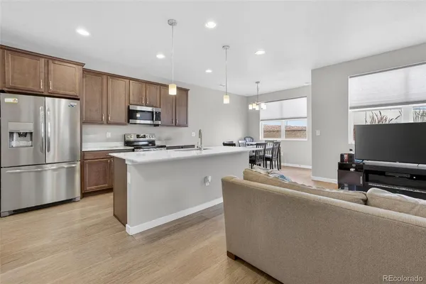 a kitchen with kitchen island a sink stainless steel appliances and a counter top space
