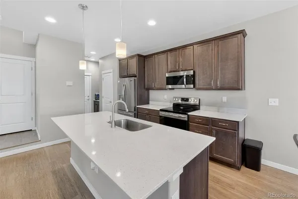 a kitchen with kitchen island a sink stove and refrigerator