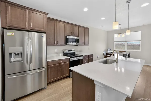 a kitchen with stainless steel appliances a refrigerator sink and microwave