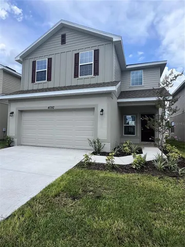 a front view of a house with a garden and plants