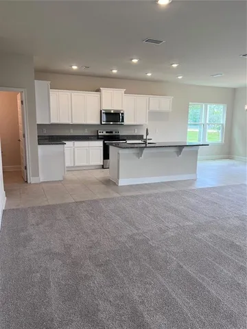 a view of kitchen with refrigerator and microwave