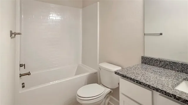 a white toilet sitting next to a bath tub