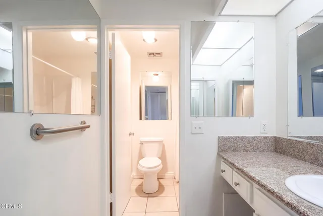 a bathroom with a granite countertop sink a mirror and a shower