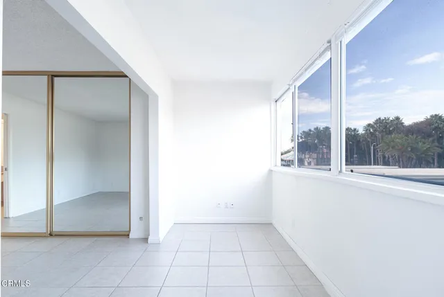 an empty room with large window and a mirror