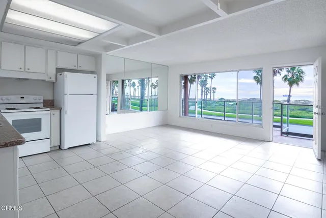 a view of kitchen with furniture and refrigerator