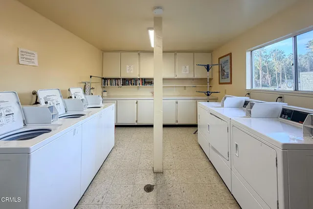 a kitchen with white cabinets a stove a sink and a window