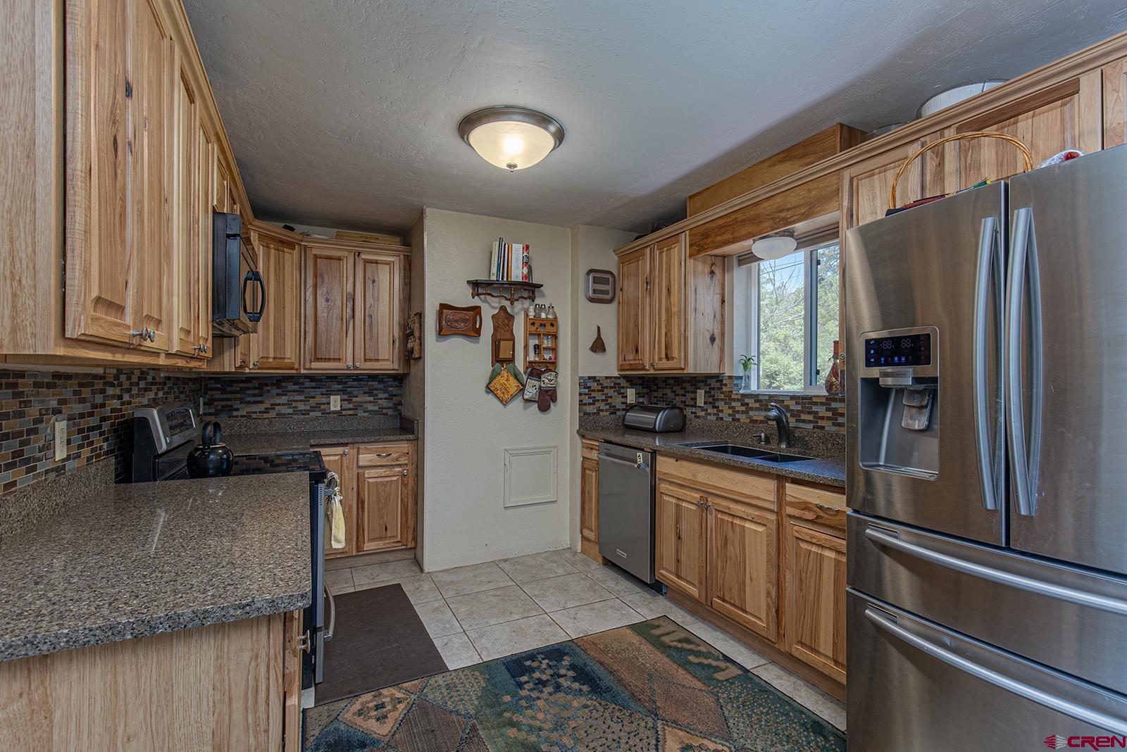 904 Florida Road Durango, CO 81301 - Photo 3 of 20 a kitchen with stainless steel appliances granite countertop a refrigerator sink and stove