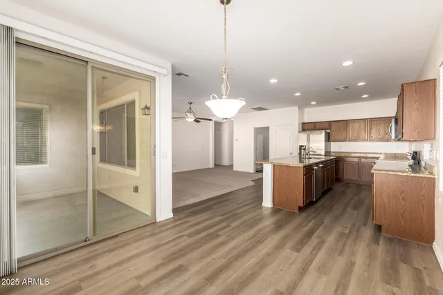 a kitchen with stainless steel appliances kitchen island granite countertop a sink and wooden cabinets