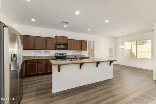 a kitchen with stainless steel appliances granite countertop a sink stove and refrigerator
