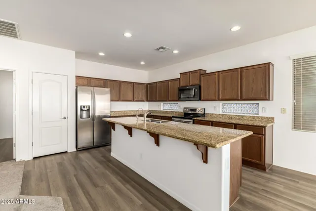 a kitchen with stainless steel appliances granite countertop a sink stove and refrigerator