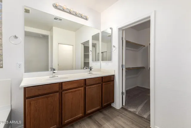 a bathroom with a double vanity sink a mirror and a bathtub