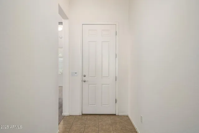 an empty room with windows and ceiling fan
